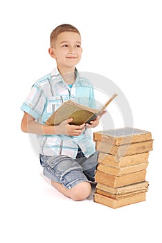 The young boy dreams near the open old book