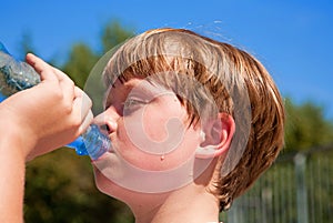 Young boy drinks water out