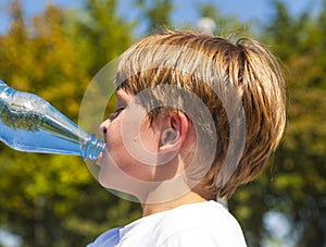 Young boy drinks water out of a bottle