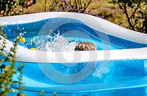 Young boy drowning in the swimming pool in the summer