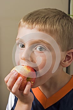 Young boy eating apple