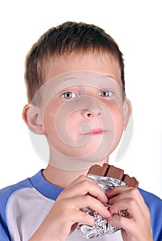 Young boy eating bar of chocolate