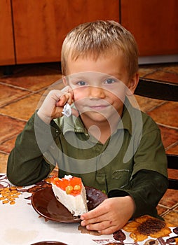 Young boy eating cheesecake