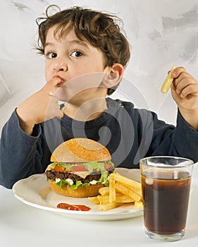 Young boy eating chessburger