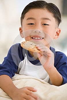 Young boy eating cookie in living room