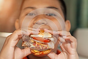 Young boy eating fresh burger, Junk food.  selective focus.