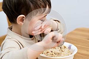 young boy eating oatmeal for breakfast