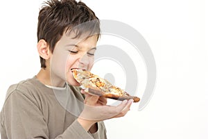 A young boy eating pizza photo