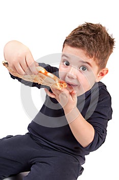A young boy eating pizza