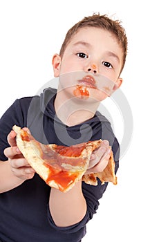 A young boy eating pizza photo