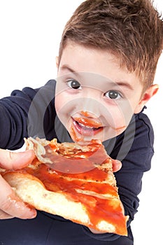 A young boy eating pizza photo