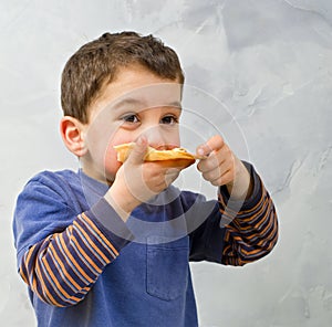 Young boy eating pizza