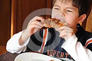 Young Boy eating Pizza