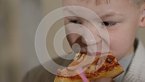 Young boy eating pizza in the restaurant