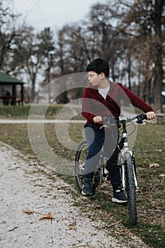 Young boy enjoying a bike ride in the park, capturing the essence of childhood freedom