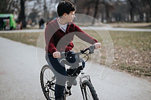 Young boy enjoying a bike ride in an urban park on a leisurely day