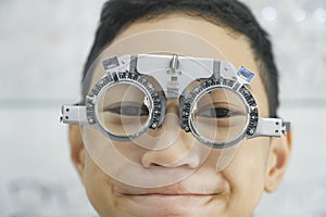 Young boy examining eyesight in optical clinic.