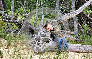 Young boy on fallen tree enjoying the fresh air and beauty outdoors. Pictured Rocks National Lakeshore