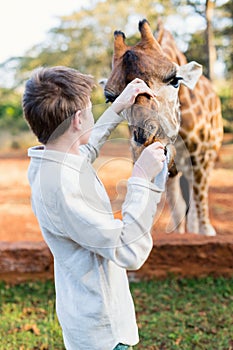 Young boy feeding giraffes in Africa