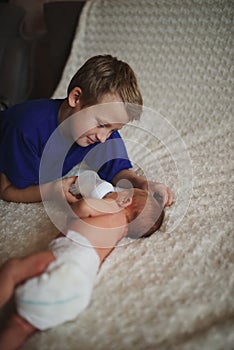 Boy feeding newborn baby with bottle of milk