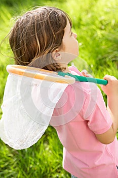 Young Boy In Field With Insect Net