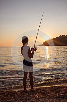 Young boy fishing on the seashore