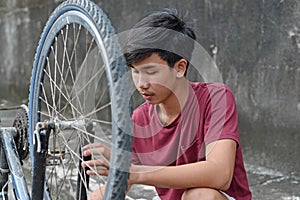 Young Boy Fixing A Bicycle