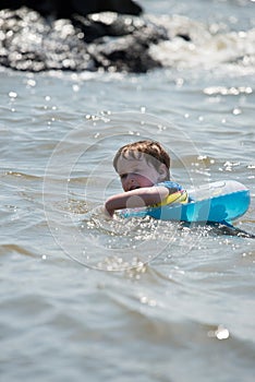 Young boy floating in inner tubes in a blissful state