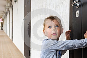 Young boy in front of a closed door