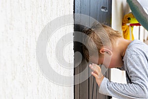 Young boy in front of a closed door