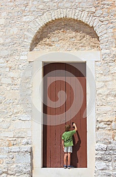 Young boy in front of an old door