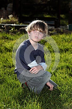 Young boy in garden looking over his shoulder
