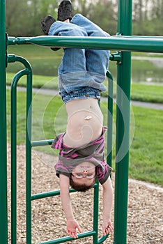 Young boy with gastric g-tube playing on monkey bars