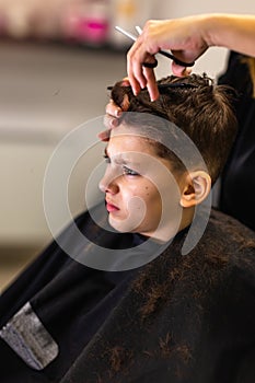 Young boy getting a haircut by hairdresser