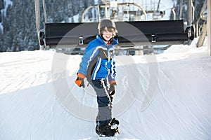 Young Boy Getting Off Chair Lift On Ski Holiday