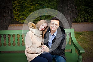 Young boy and girl hugging and kissing, sitting on the bench