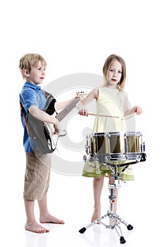Young boy and girl playing drums and guitar