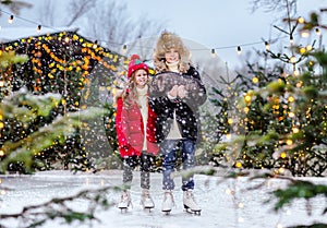 Young boy and girl posing on an ice rink with black little pig. Snowing.