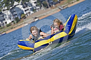 Young Boy and Girl Riding a Tube on Water
