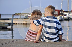 Young boy and girl sitting in a marina