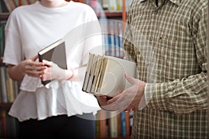 Young boy and girl students with books in the library