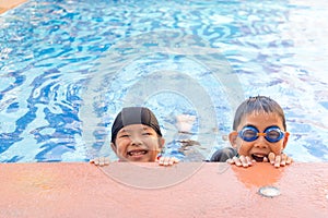 Young boy and girl swimming in pool.