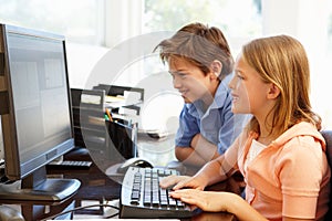 Young boy and girl using computer at home