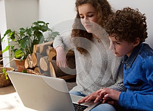 Young boy and girl using laptop together