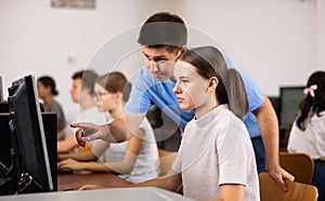 Young boy and girl using personal computer in school