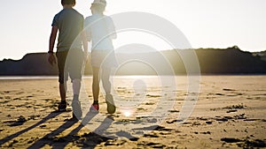 Young Boy And Girl Walking On The Beach Having Fun Together