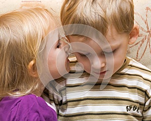 Young boy and girl are whispered