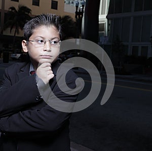 Young boy with glasses pondering