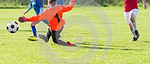 Young Boy Goalkeeper Saving A Football In A Game Of Soccer