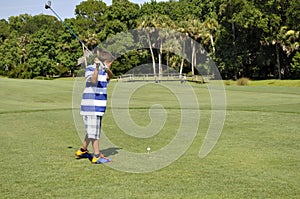 Young boy golfing